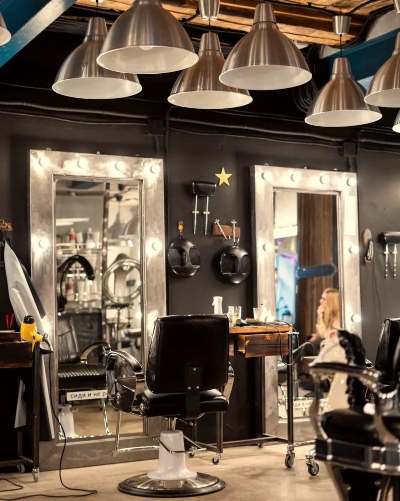 Barbearia com cadeiras e espelhos iluminados